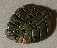 Leaf carved from plumite jasper with pink spots.