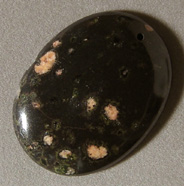 Oval shaped pendant bead from plumite jasper.