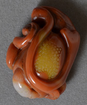 Carving of bird in foliage from red and yellow agate.
