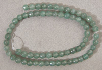 Smaller faceted round beads from light green emerald.