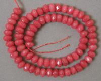 Faceted rondelle beads from light opaque ruby quartz.