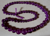 Graduated round bead strand from purple jade.