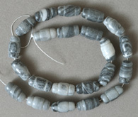 Carved barrel beads from gray and white spiderweb Jasper.